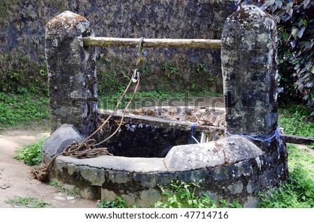 Historic, old traditional water well with rope and pulley in a village in Coorg in Karnataka, India.
