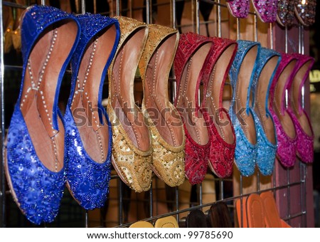 A collection of colorful Indian and Pakistani style ladies sandal displayed in a market place.