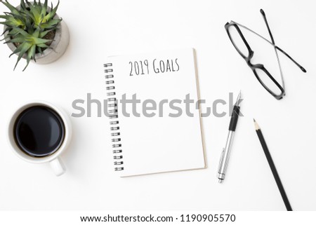 Notebook with 2019 Goals text on top of white office desk table