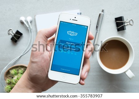 CHIANG MAI, THAILAND - DEC 20,2015: A man holds Apple iPhone with Skype application on the screen. Skype is an application that providing text chat, video chat and voice calls