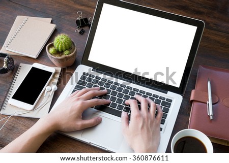 A man is working by using a laptop computer on vintage wooden table. Hand typing on a keyboard.