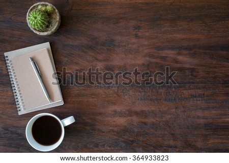 Hipster vintage office desk table with notebooks, pen and a cup of coffee. Top view with copy space.