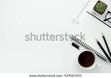 Working desk table with notebook, pen, pencil and cup of coffee. Top view with copy space.