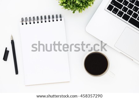 White designer office desk table with blank notebook page with pen, laptop computer and cup of coffee. Top view, flat lay.