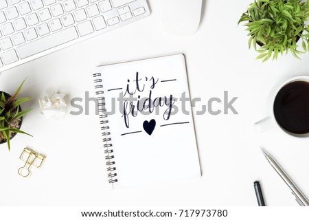 Notebook with it\'s friday calligraphy text is on top of white office desk table. Top view, flat lay.