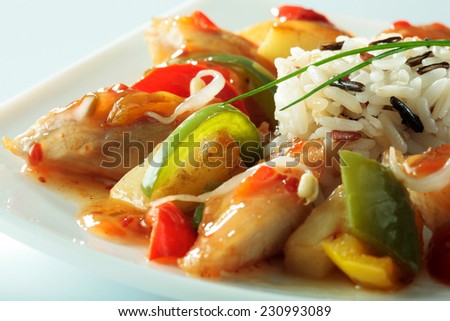 Chinese specialty with chicken, rice, vegetables and soybean sprouts close-up on white plate