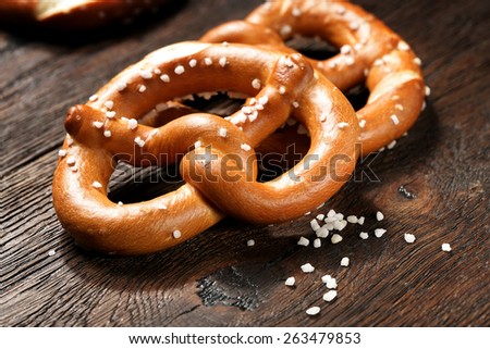 Fresh pretzels with sea salt close-up on  dark board background
