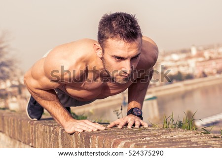 Man fitness model training pushups outdoors