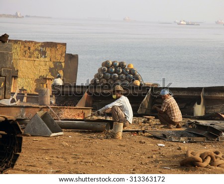Mumbai/India - 23/11/14 - Ship breakers at work in Darukhana Ship Breaking yard, cutting through lumps of steel on the beach