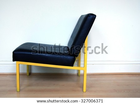 Yellow framed chair against wall