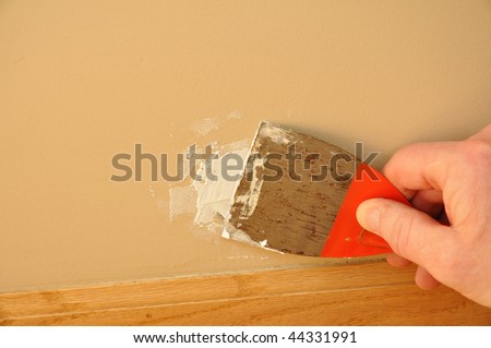 Putty Knife with Spackling Paste to Repair Wall Damage