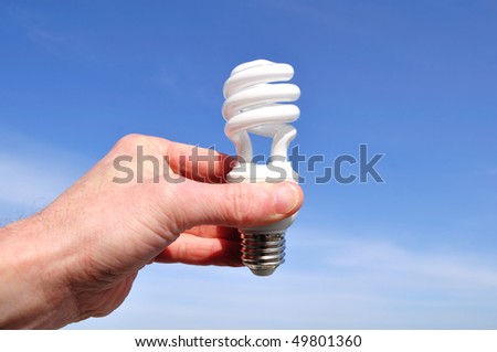 Hand Holding a Compact Fluorescent Light (CFL) Against a Blue Sky