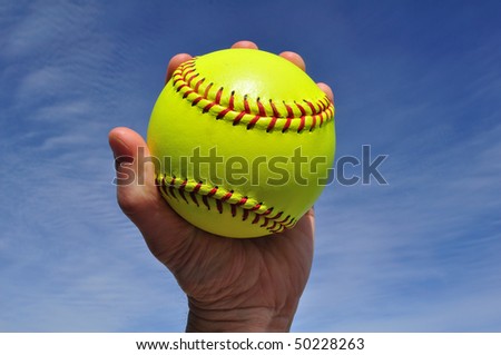 Player Gripping a Yellow Softball Against a Blue Sky