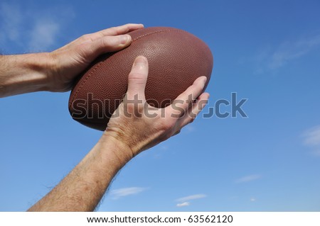 Receiver Catching an American Football Pass Against a Blue Sky