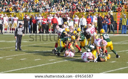 GREEN BAY, WI - NOVEMBER 22 : Green Bay Packers defense gang tackling in a game at Lambeau Field against the San Francisco 49ers on November 22, 2009 in Green Bay, WI