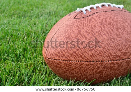 Close-up of an American Football on Real Grass Turf of a Football Field