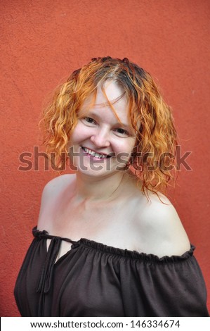 natural portrait of a  middle age red hair woman against red background