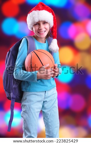 Child with Santa Claus red hat and ball. Christmas, New Year, holiday activities, sports celebration