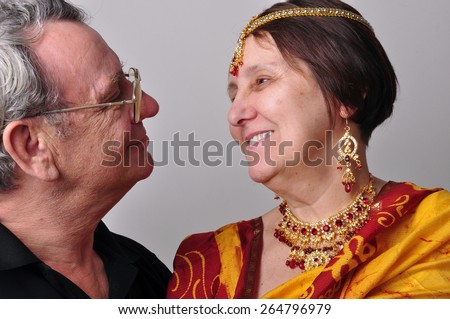 Portrait of happy senior couple looking at each other. Husband and wife wearing Indian clothing sari, tikka and necklace