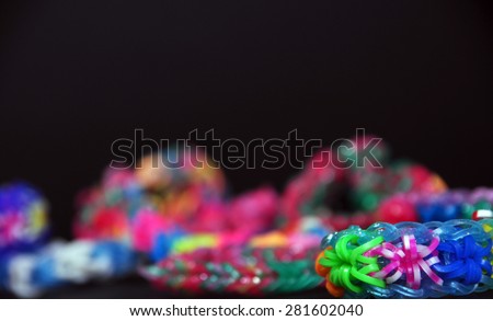 Colorful background rainbow colors rubber bands loom bracelets on black background. Copy space.