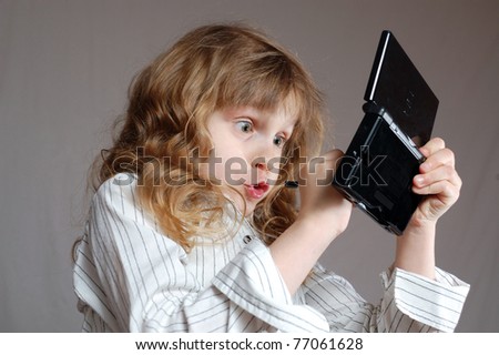 girl playing video game on a mini computer