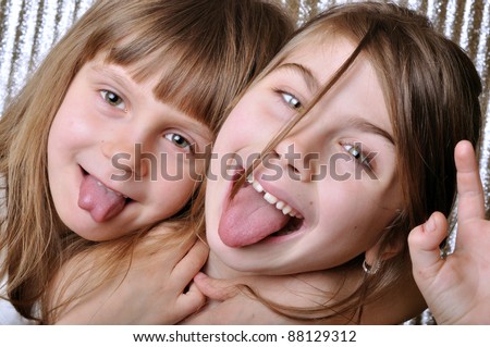 two playful girls with thier tongues out