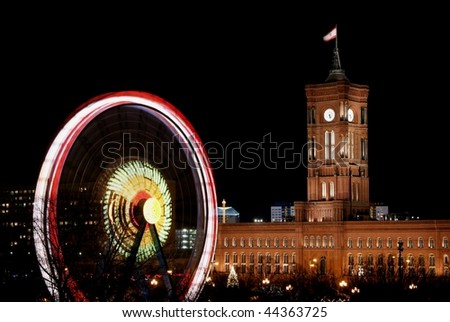 The berlin town hall ,red rathaus ,with a big wheel at the side depicting political changes ,at night