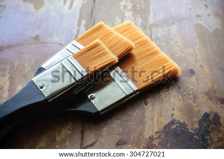 Set of old brush for coloring the walls/ Brush painting wooden furniture, close up/Paintbrush on wood background