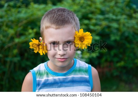 8-year boy with flowers on ears having fun