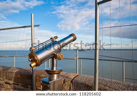 Telescope aiming Atlantic Ocean and island Tombelaine on view point on Mont Saint-Michel, France