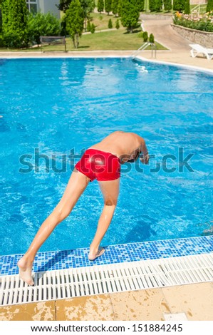 A boy is ready to jump into swimming pool