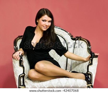 young attractive girl sitting in antique armchair