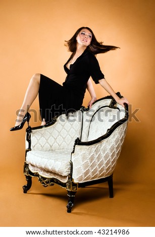 young beautiful woman and antique armchair