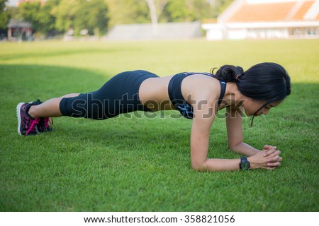 fitness woman doing plank core exercise workout on grass