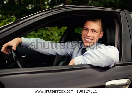 Young man  sitting in the car smiling