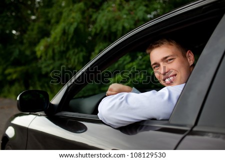 Young man sitting in the car smiling