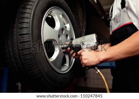 Auto mechanic changing car wheel