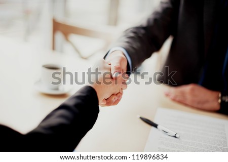 Handshake closeup of businesswoman and businessman.