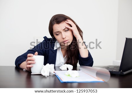 Sick woman at work drinking coffee