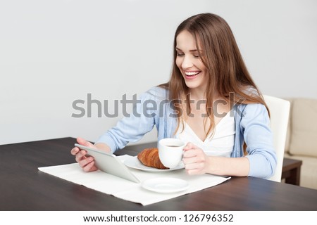 Woman eating breakfast and surfing the net