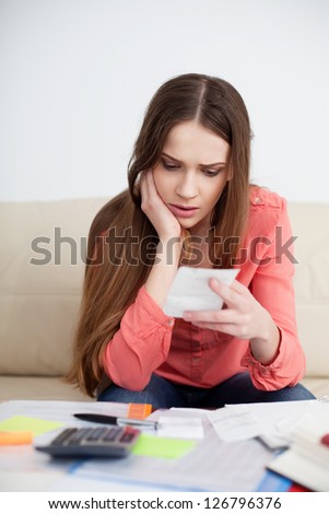 Stressed woman looking at bills