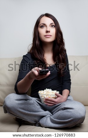 Beautiful young woman watching television