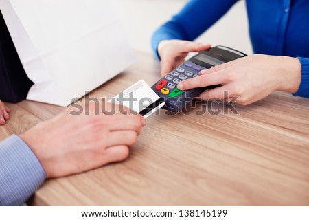 Closeup of man buying with credit card in shop.