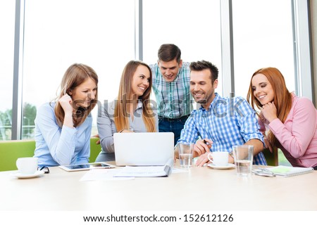 Group Of Young Happy Employees Working Together With Laptop