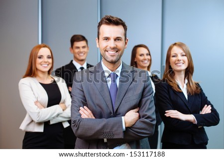 Team leader stands with coworkers in background