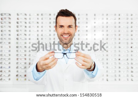 Optometrist, Optician Or Eye Doctor Showing Glasses With Many Eyeglasses In Background