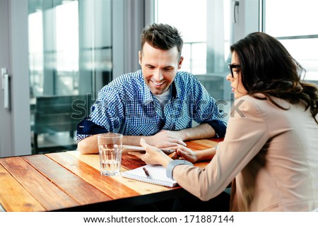 Young couple at a table looking at a digital tablet