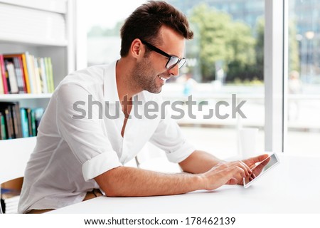 Male student browsing the web on his tablet
