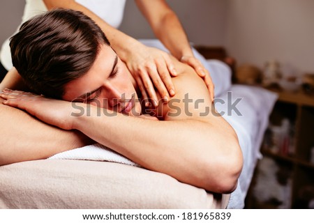 Handsome man lying down and getting a massage