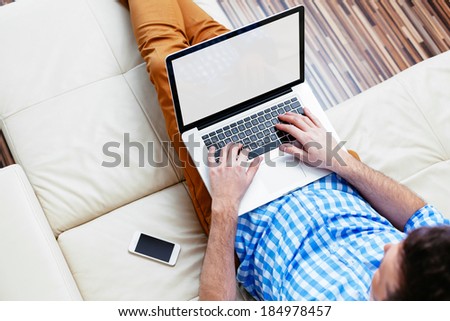 Man sitting on a sofa and browsing the web
